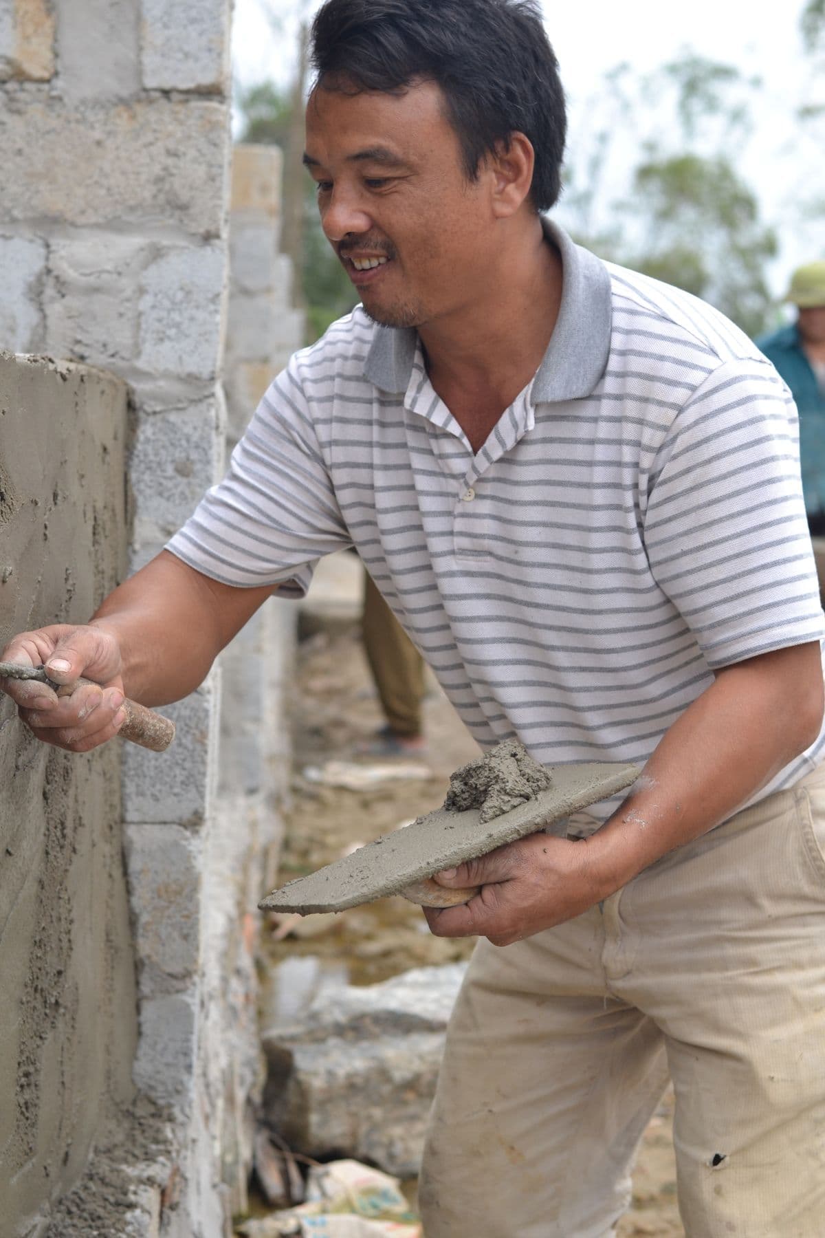 Artisan appliquant un mortier sur un mur